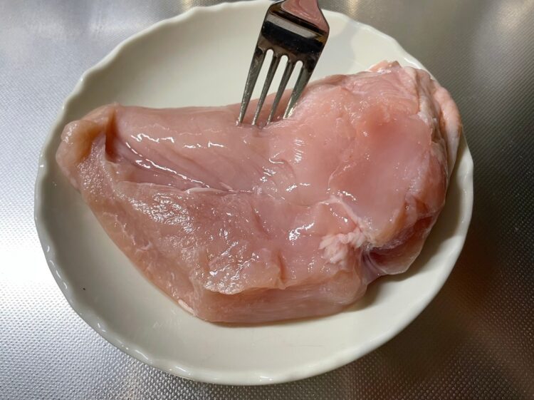 鶏むね肉にフォークを刺す